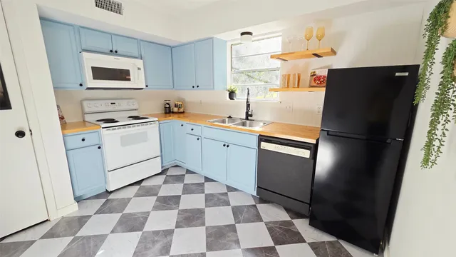 a kitchen with a refrigerator a sink and a microwave