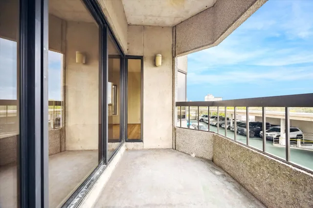 a view of a glass door with a balcony next to a yard