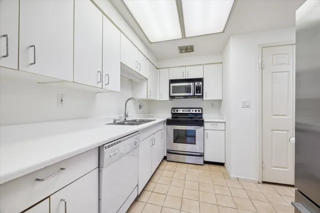 a kitchen with cabinets stainless steel appliances and a counter space