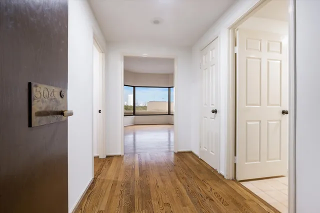 a view of a hallway with wooden floor