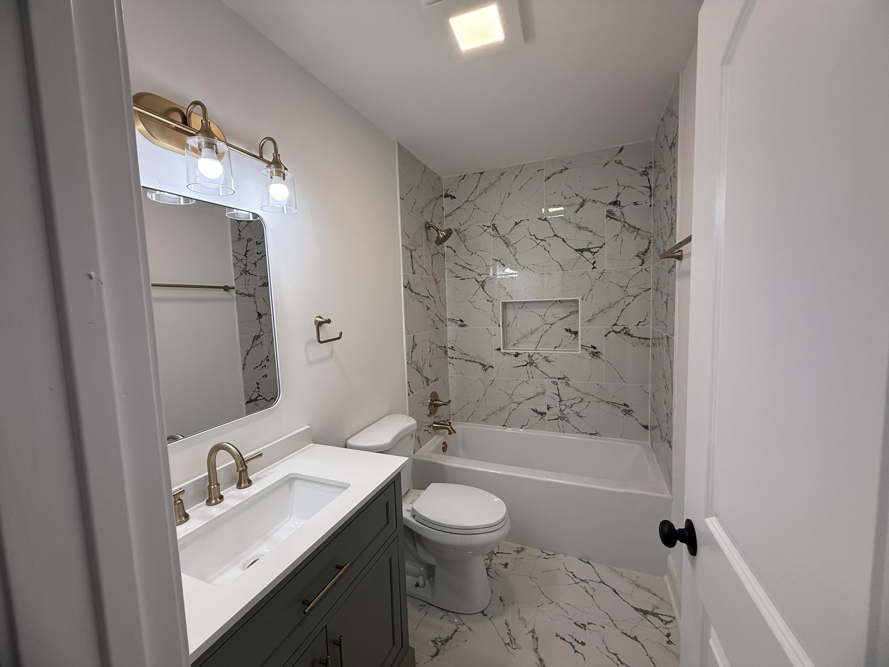 15895 Sherman Street Lowell, IN 46356 - Photo 26 of 36 a bathroom with a granite countertop sink toilet a shower and a mirror