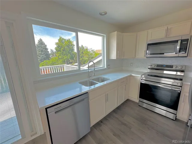a kitchen with a stove a sink and a microwave