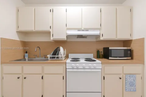 a kitchen with stainless steel appliances granite countertop white cabinets sink and dishwasher