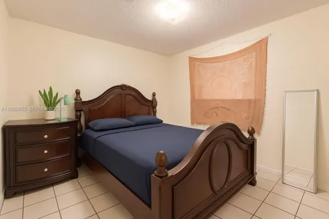 a bedroom with a bed and a potted plant