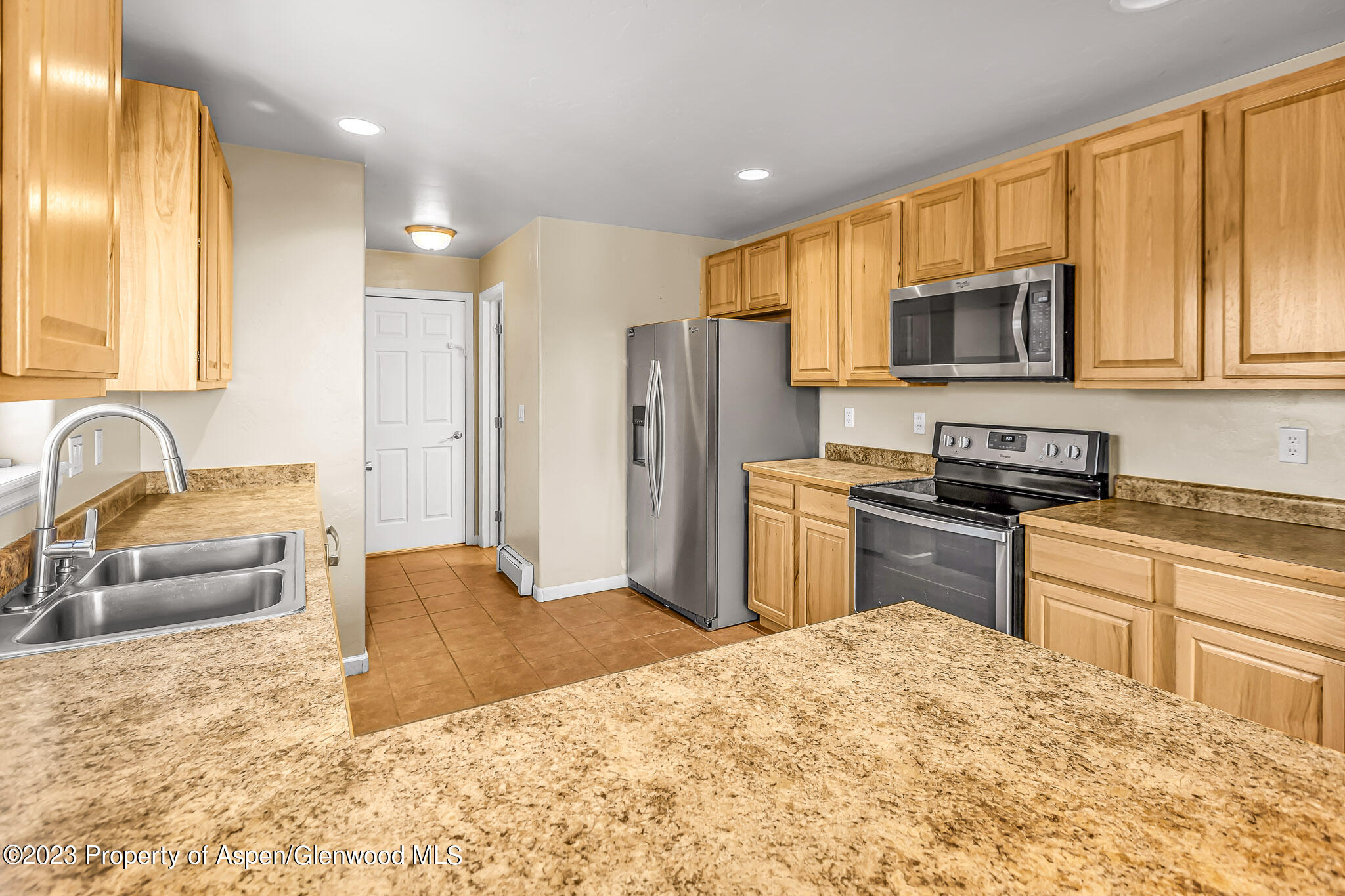 2462 Pioneer Way Rifle, CO 81650 - Photo 5 of 29 a kitchen with stainless steel appliances granite countertop a refrigerator stove top oven and sink