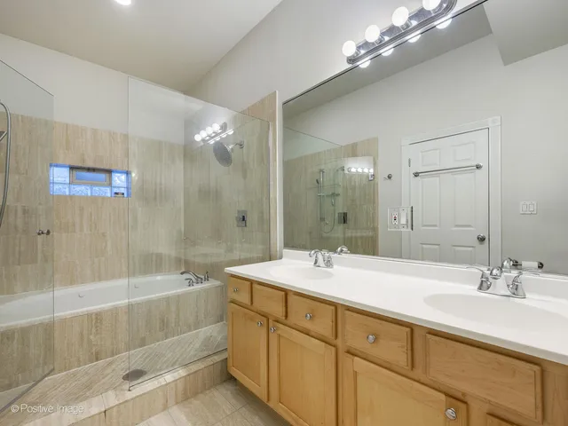 a spacious bathroom with a sink a large mirror and shower