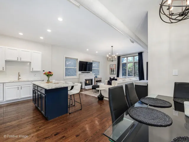 a living room with furniture a flat screen tv and kitchen view