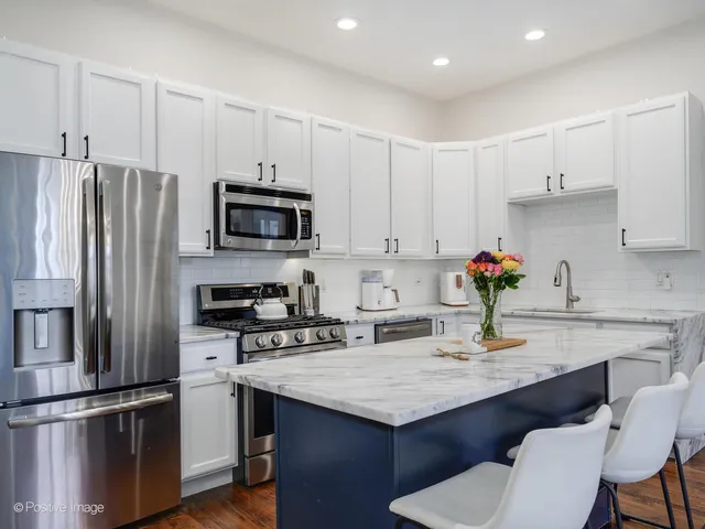 a kitchen with granite countertop a sink cabinets and stainless steel appliances