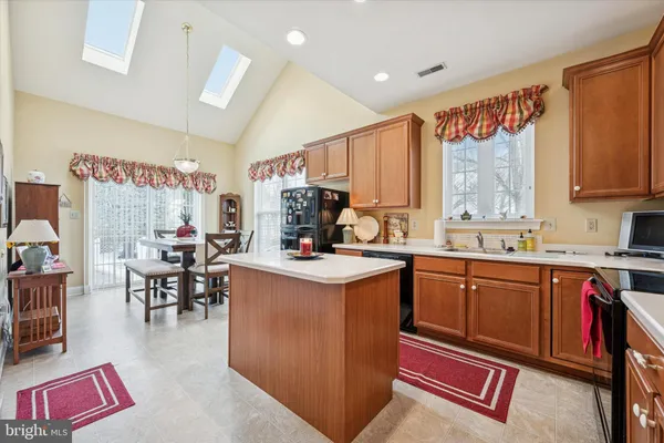 a kitchen with stainless steel appliances granite countertop a stove a sink dishwasher and a dining table with the kitchen view