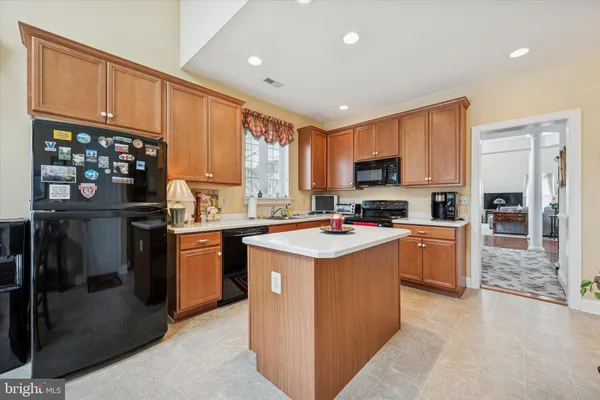 a kitchen with kitchen island a sink dishwasher stove and refrigerator