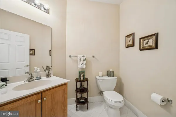 a bathroom with a granite countertop toilet sink and mirror