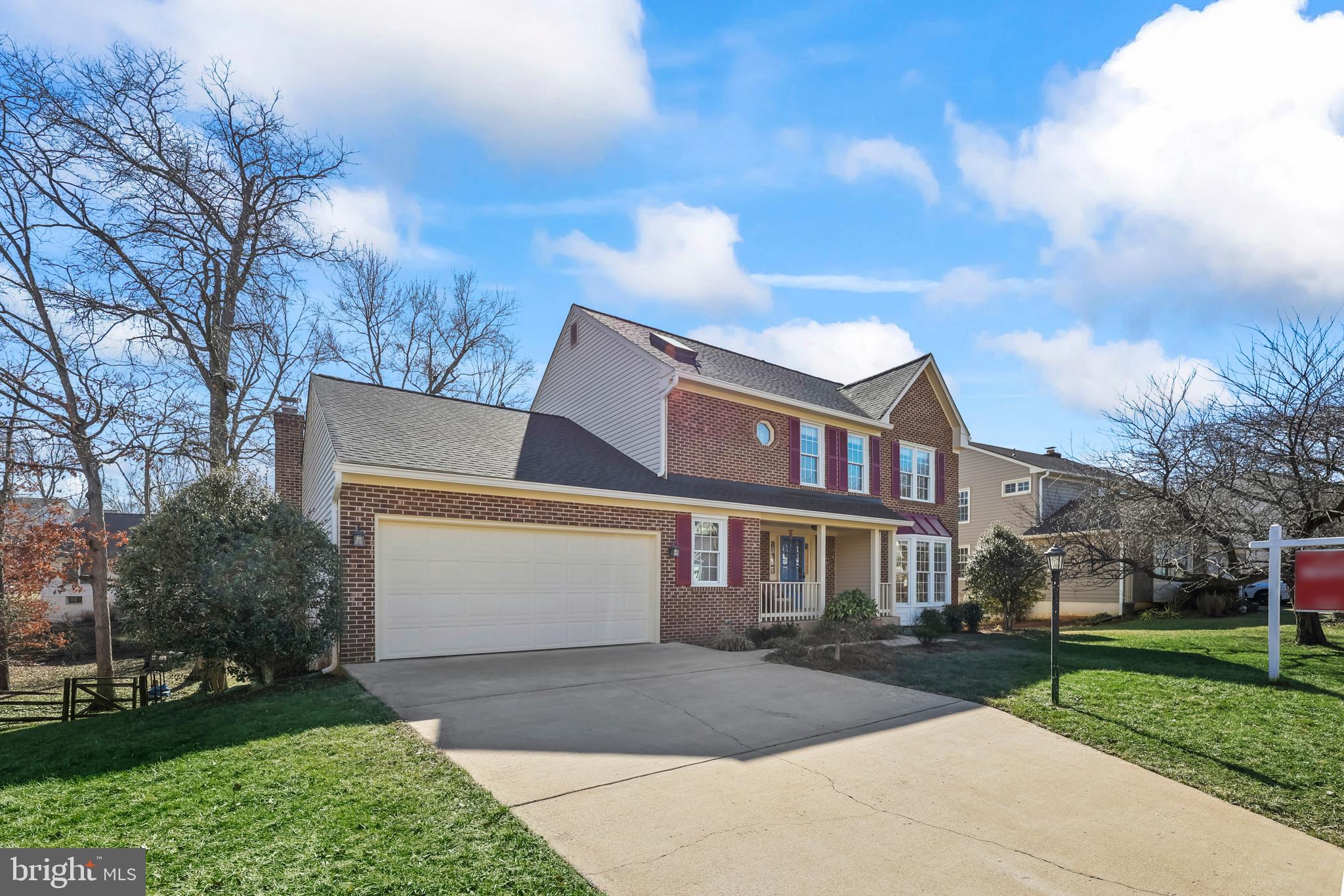 a front view of a house with a garden and trees