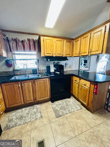 a kitchen with stainless steel appliances granite countertop a stove a sink dishwasher and cabinets
