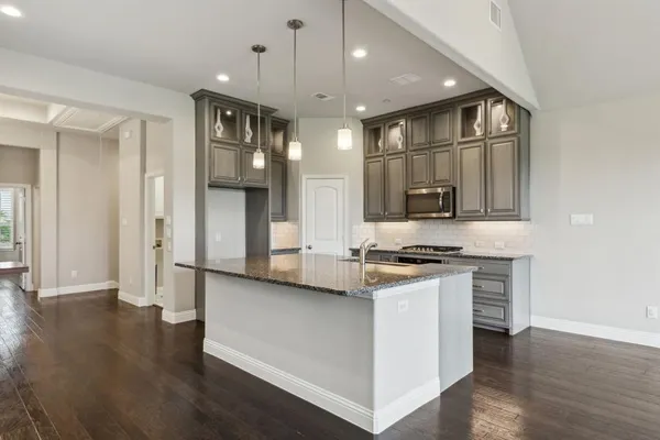 a kitchen with stainless steel appliances granite countertop a stove and a refrigerator