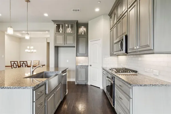 a kitchen with stainless steel appliances granite countertop a sink stove and refrigerator
