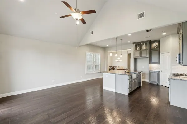a large kitchen with cabinets wooden floor and stainless steel appliances