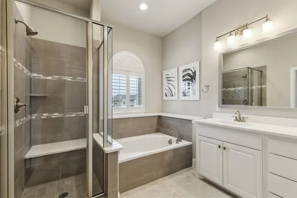 a bathroom with a tub sink shower and mirror