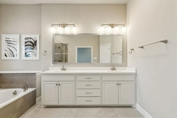 a spacious bathroom with a granite countertop sink mirror and bathtub