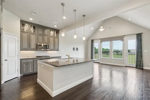 a kitchen with stainless steel appliances granite countertop a sink a stove and a large window