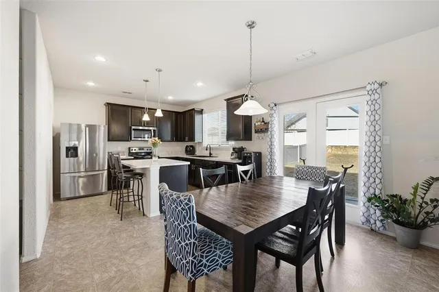a view of a dining room and livingroom with furniture a kitchen and chandelier