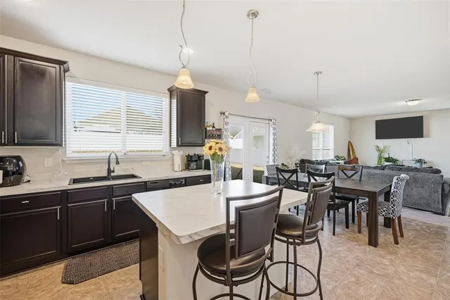 a kitchen with a dining table chairs sink and cabinets