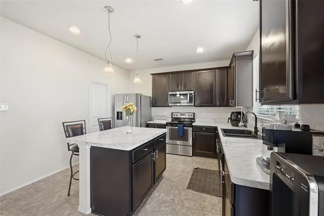 a large kitchen with a large counter top appliances and cabinets