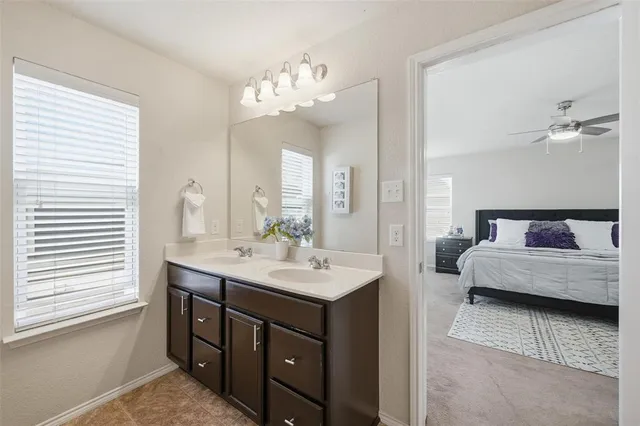 a en suite bathroom with a double vanity sink and a mirror