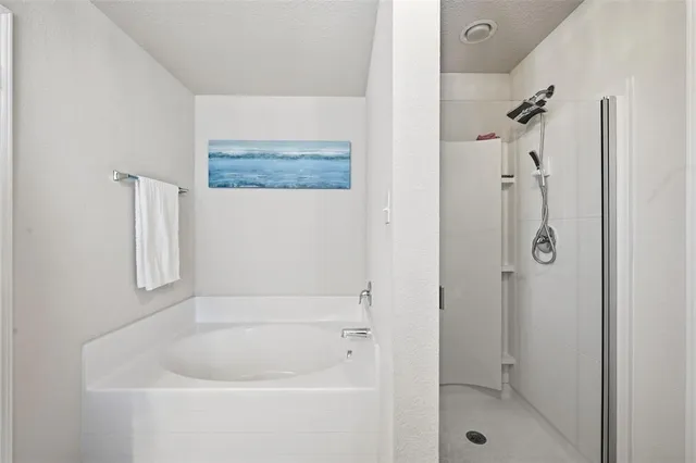 a white bath tub sitting next to a shower
