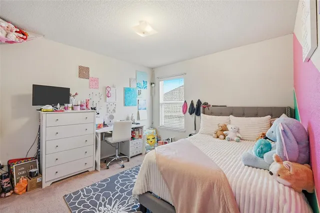 a bedroom with a bed and a flat tv screen on dresser