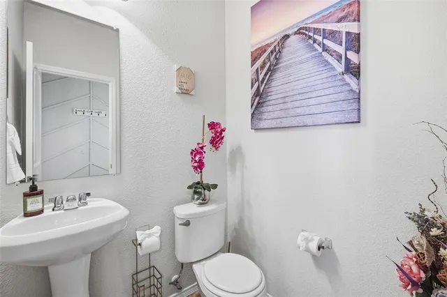a bathroom with a sink mirror and toilet