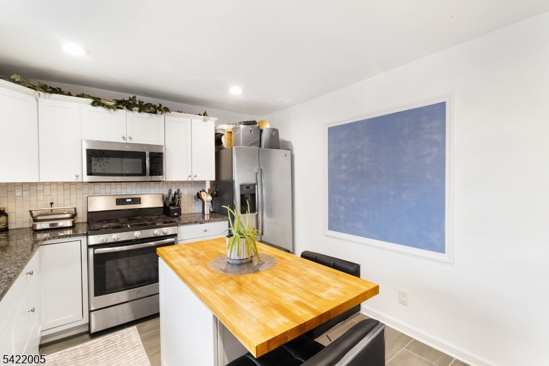 60 Searing Street Dover, NJ 07801 - Photo 4 of 23 a kitchen with stainless steel appliances stove top oven and refrigerator