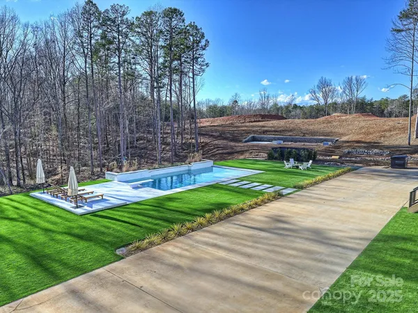 a view of a backyard with swimming pool