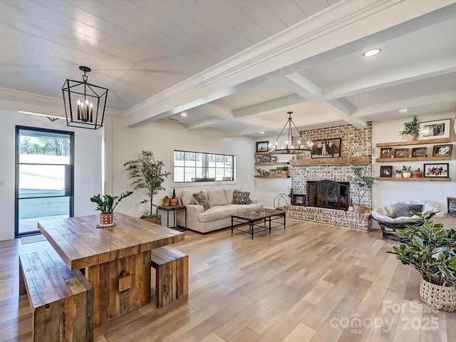 a living room with furniture a fireplace and a chandelier
