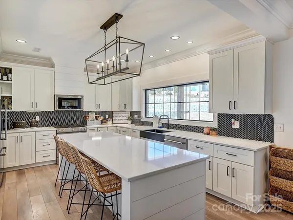 a kitchen with a sink a counter space appliances and cabinets