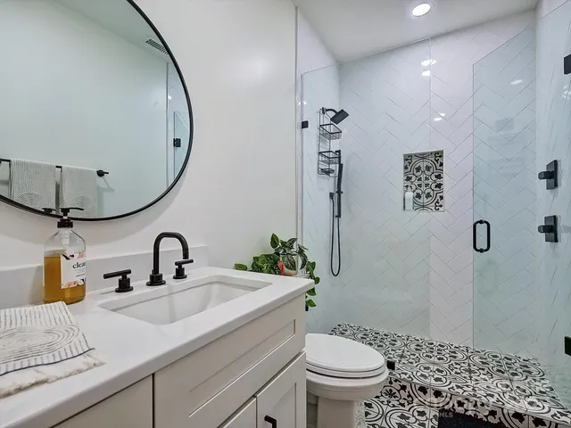 a bathroom with a sink a toilet and shower