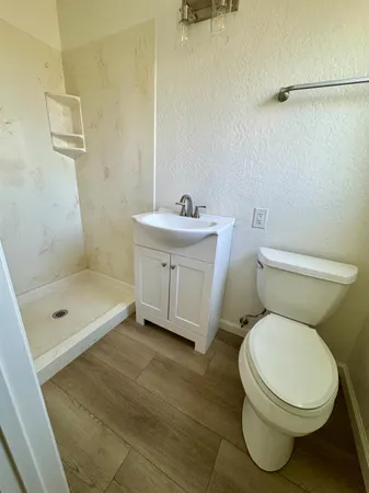 a white toilet sitting next to a bath tub