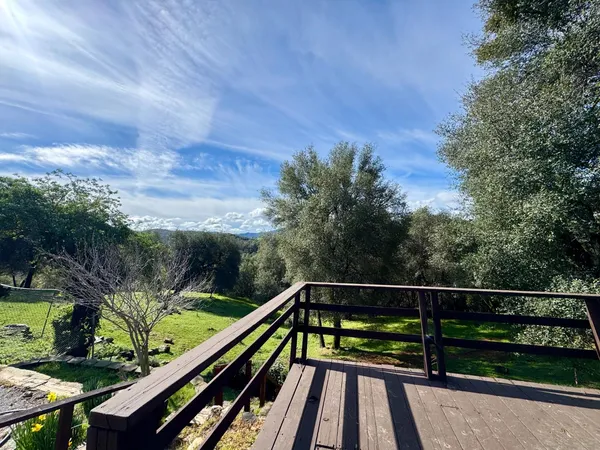 a view of balcony with wooden floor and fence