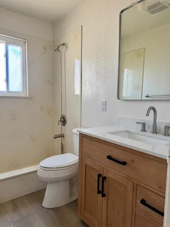 a bathroom with a double vanity sink a mirror and a toilet