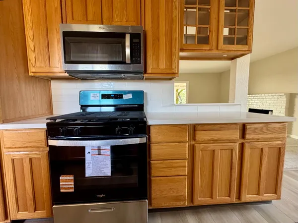 a kitchen with stainless steel appliances granite countertop a stove and a microwave