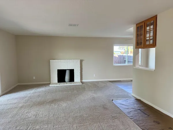 an empty room with windows and fireplace