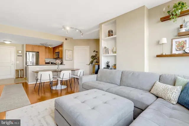 a living room with furniture and a dining table with kitchen view