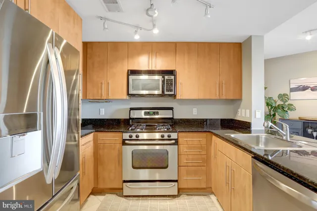 a kitchen with stainless steel appliances a stove a sink and a microwave