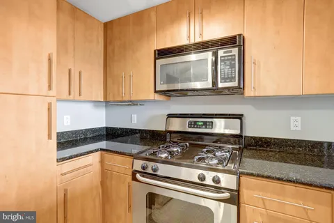a kitchen with granite countertop a stove and a microwave