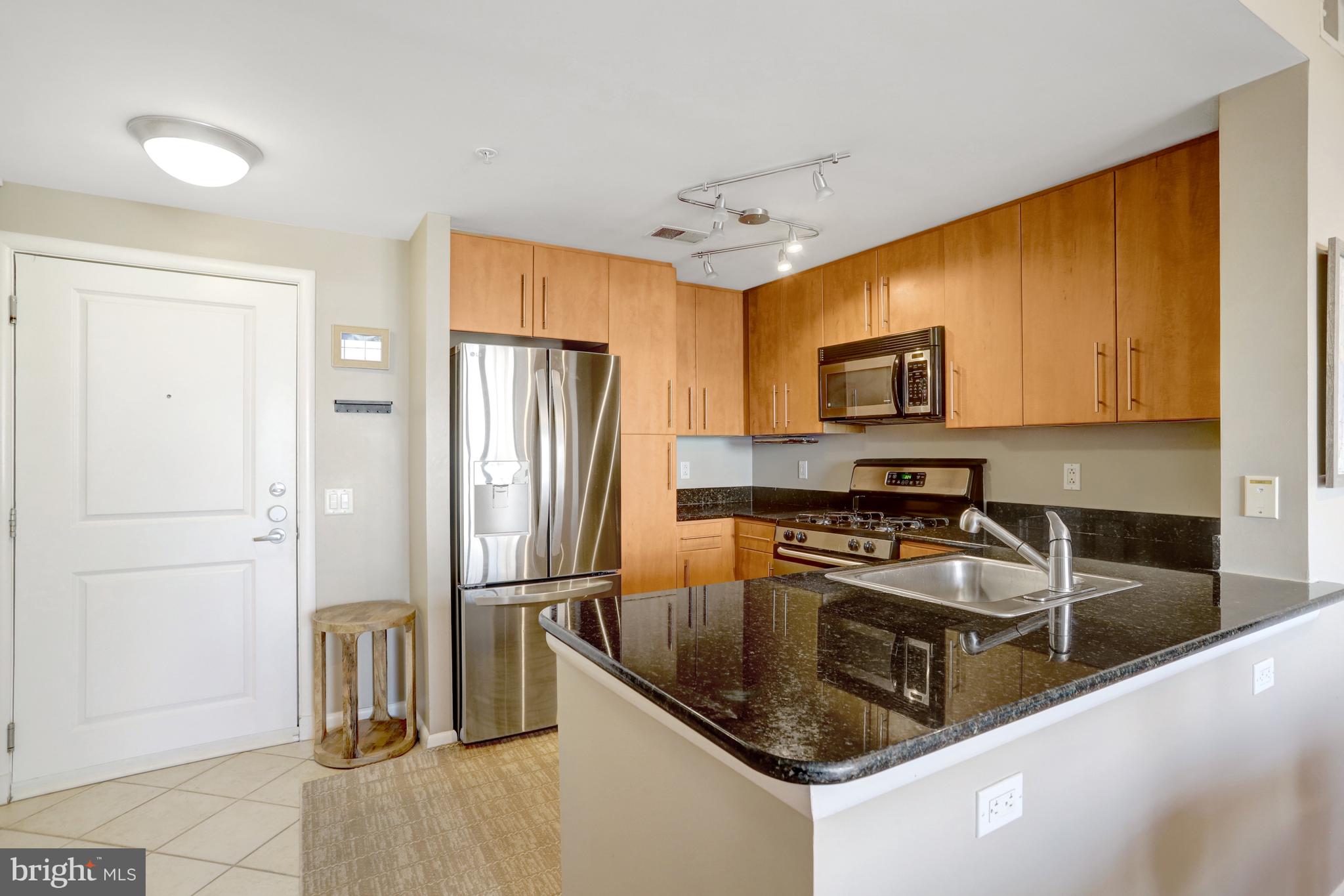 1021 North Garfield Street, Unit 914 Arlington, VA 22201 - Photo 4 of 63 a kitchen with granite countertop a refrigerator and a sink