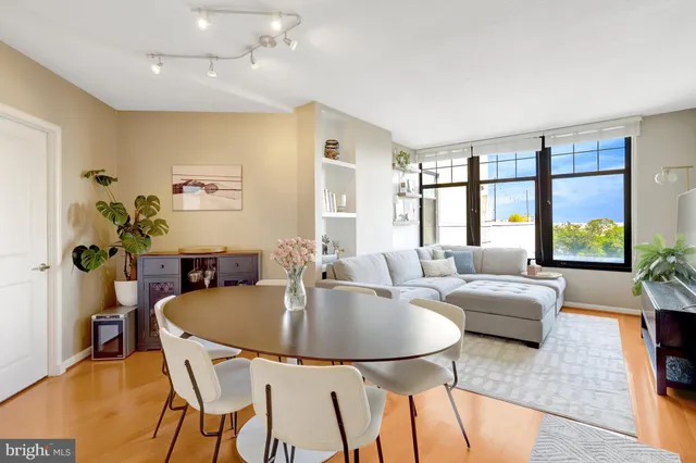a dining room with furniture and a floor to ceiling window