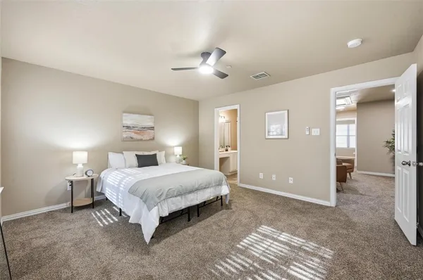 a spacious bedroom with a bed and a lamp