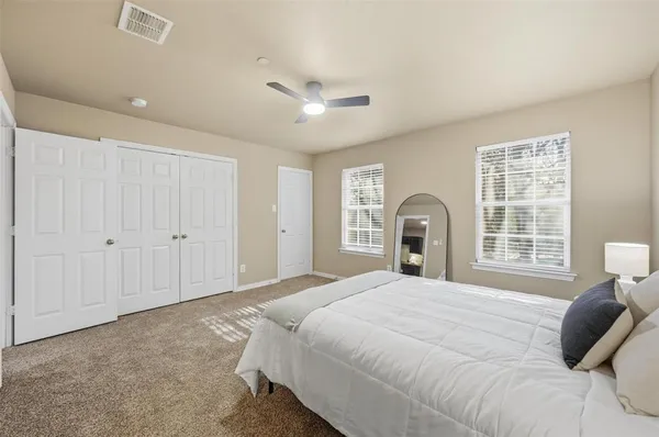 a bedroom with a bed and a large window