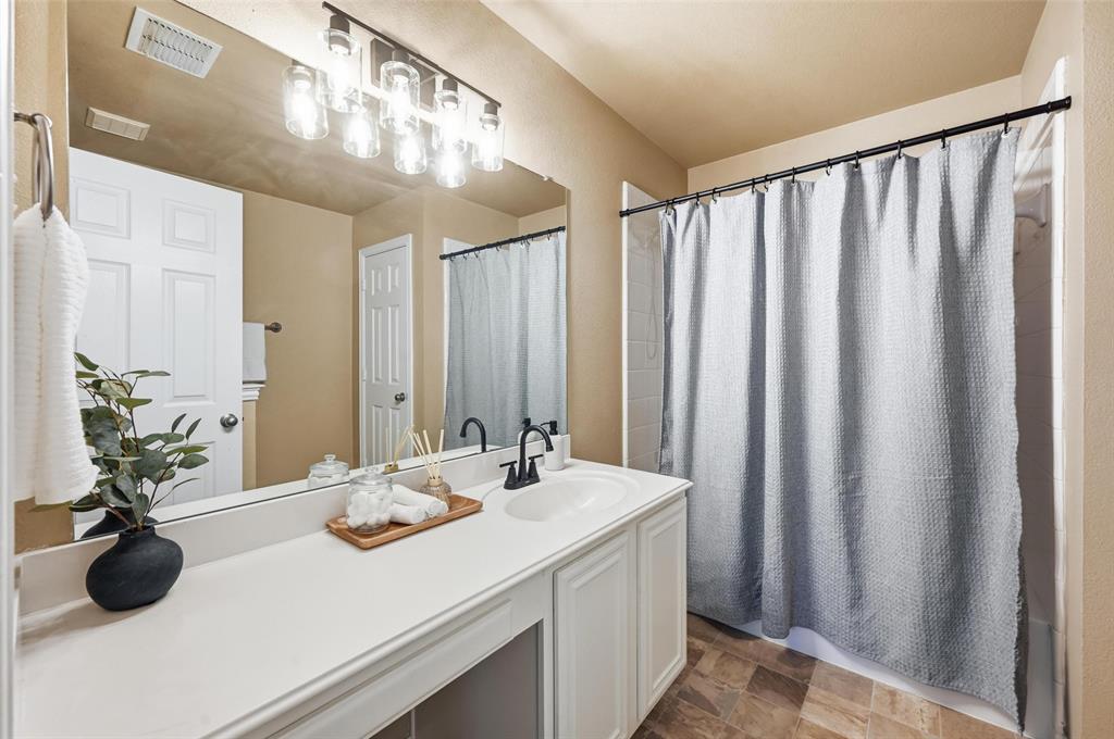 2522 Durango Ridge Drive Bedford, TX 76021 - Photo 19 of 35 Bathroom featuring vanity, stone finish floors, and shower / tub combo with curtain