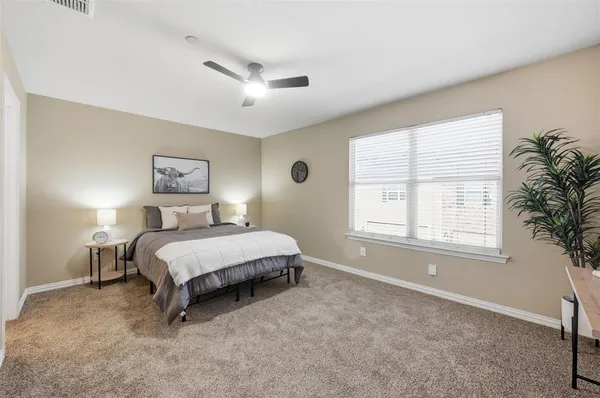 a spacious bedroom with a bed a wall painting and a window