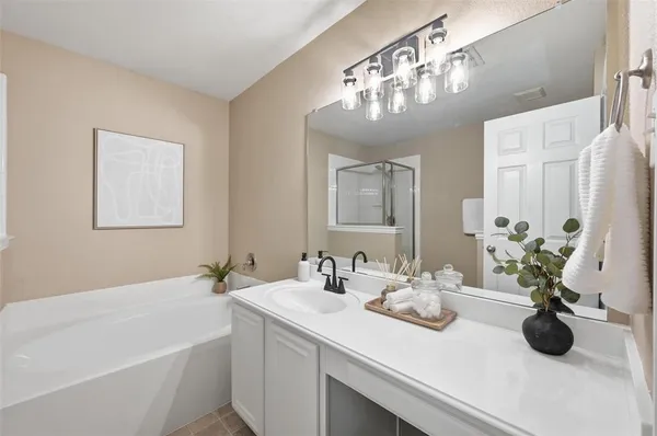a bathroom with a sink a large mirror and shower